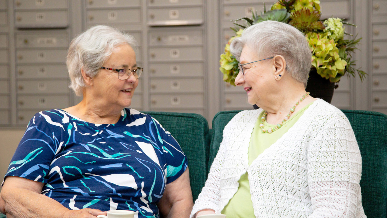 Two residents talking together in a Willow Creek common area