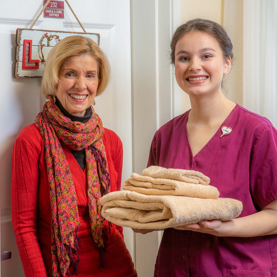A team member delivering fresh linens to a resident at Willow Creek